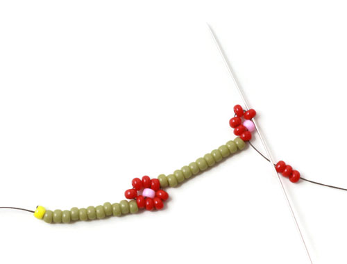 DIY daisy chain armbånd med røde blomster