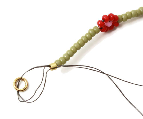 daisy chain armbånd i grønt med røde blomster