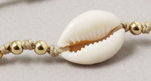 armbånd med cowrie skaller og forgyldte perler